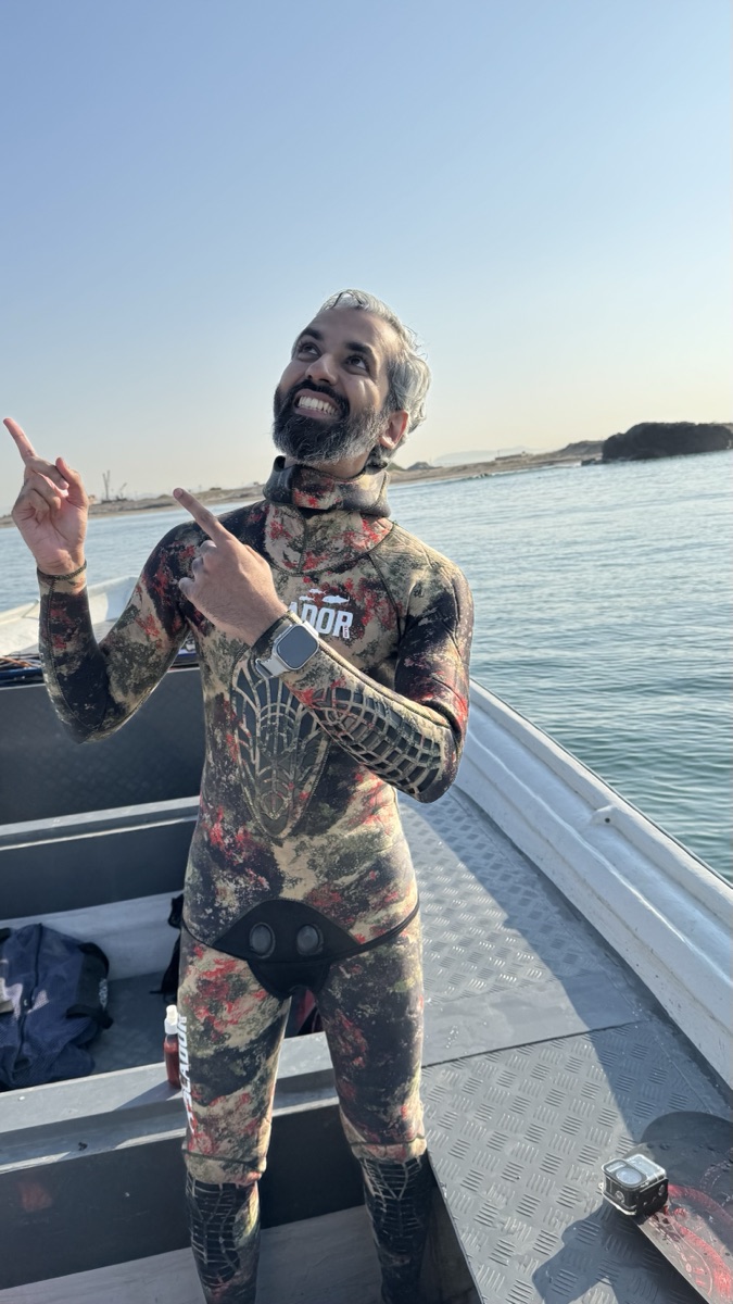 Sameer in spearfishing wetsuit on a boat off Charna Island